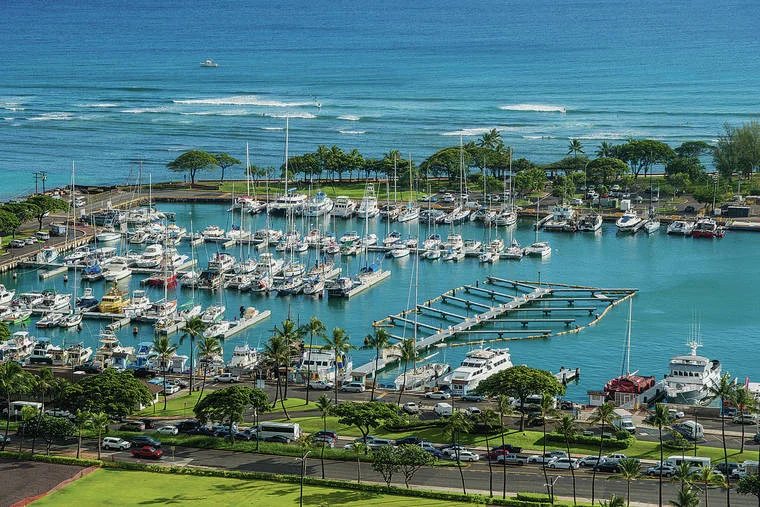 The parasail boat tied up at Kewalo Basin Harbor on a calm morning with guests boarding